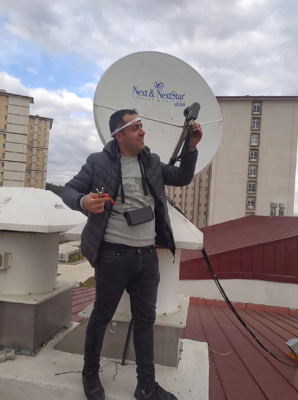 Çanak antenin LNB bağlantısını kontrol eden teknisyen